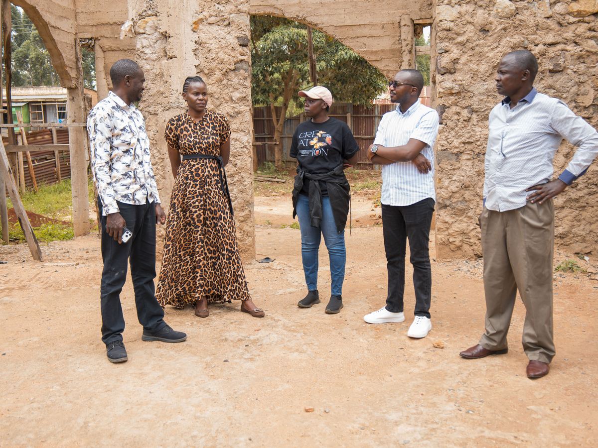 Five people walking through the building site