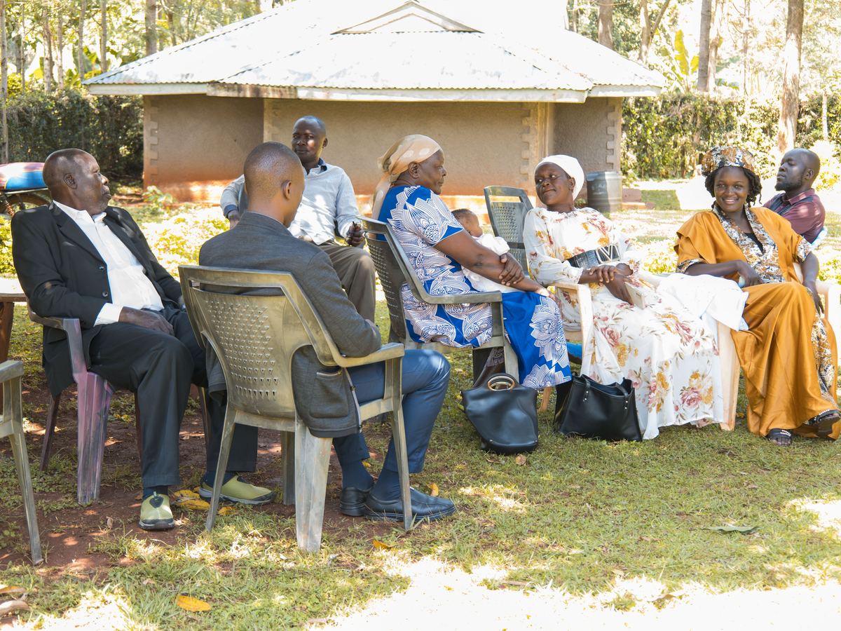 Community members seated outdoors during a meeting